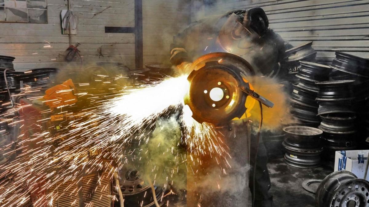 A worker of Lithuanian metal processing company 'Kalvis' welds old wheel rims to create heating stoves for Ukrainian civilians and soldiers in Siauliai, Lithuania. Credit: AFP Photo