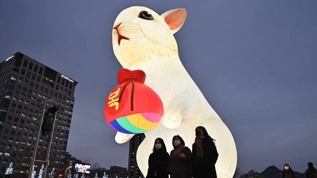 People walk past an illuminated lantern for the upcoming Year of the Rabbit during Seoul Lantern Festival at Gwanghwamun square in Seoul on December 19, 2022. Credit: AFP Photo