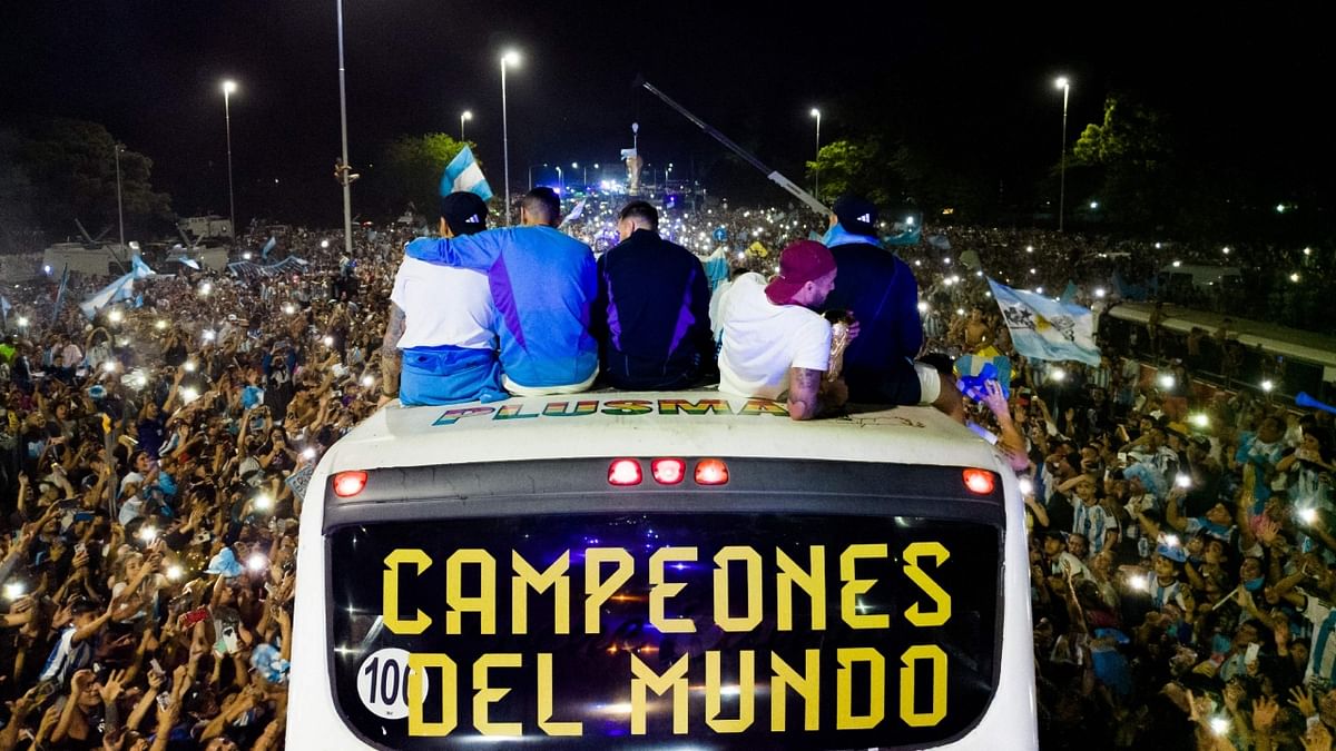 Argentina's players celebrate on board a bus with a sign reading