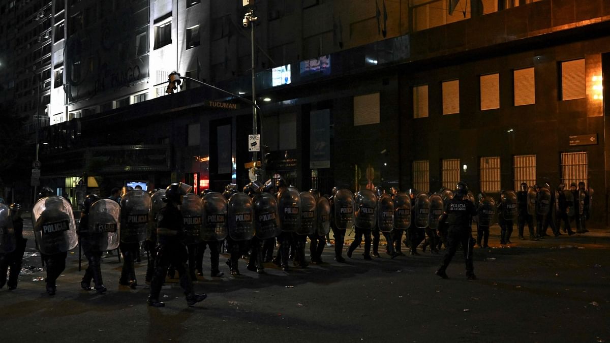 Riot police stand guard after clashes with fans of Argentina following the celebration of the team's arrival from the Qatar 2022 World Cup tournament, in Buenos Aires. Credit: AFP Photo