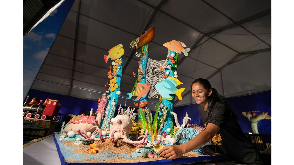A baker gives finishing touches to a 340kg cake model of the Great Barrier Reef during the press conference of 48th annual Cake Show, in Bengaluru Credit: Credit: PTI Photo
