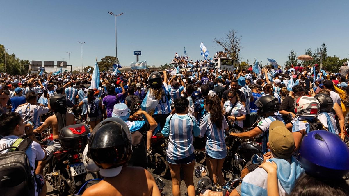 Fans of Argentina cheer as the team parades on board a bus in Buenos Aires after winning the World Cup. Credit: AFP Photo