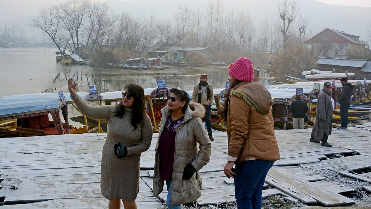 Tourists take selfies near the Dal Lake as the 40-days harshest winter period Chillai Kalan begins, in Srinagar. Credit: PTI Photo