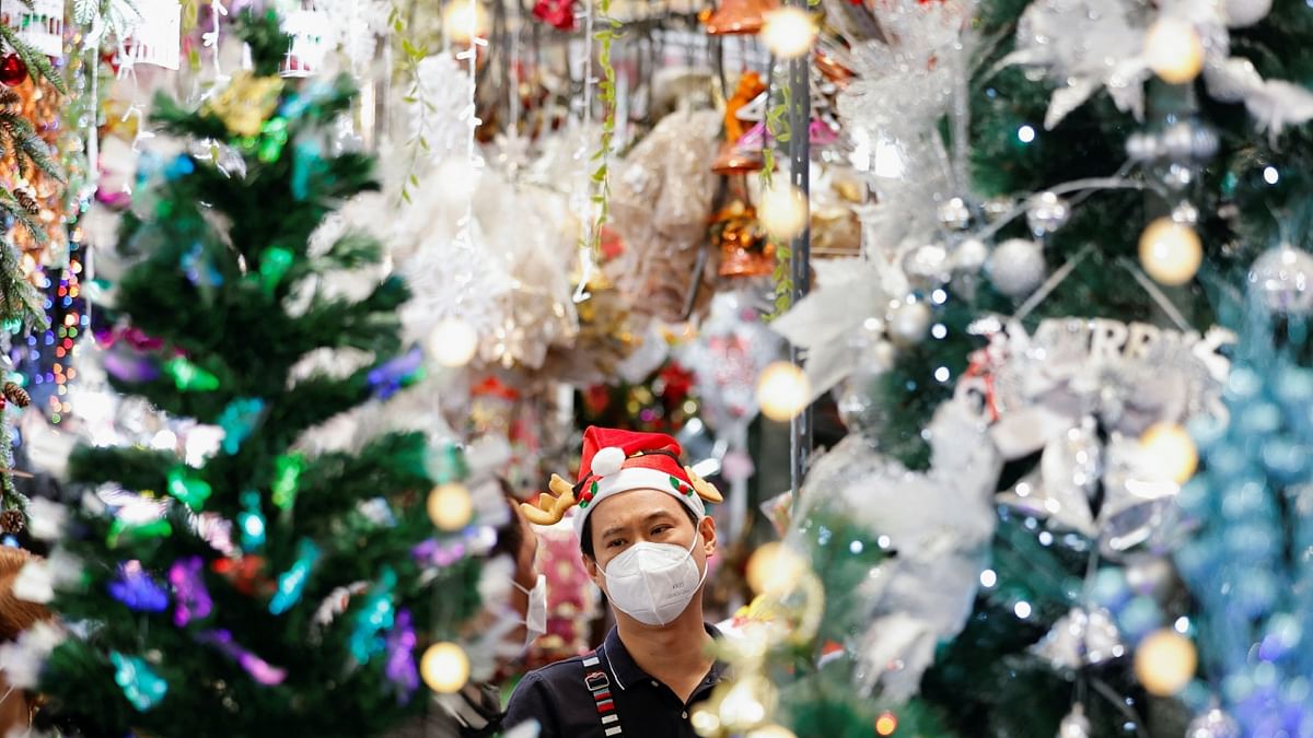 A shopkeeper wearing a Santa's hat serves a customer at a Christmas market inside a shopping mall in Jakarta. Credit: Reuters Photo