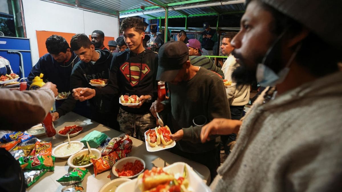 Migrants from Venezuela, Honduras, Nicaragua and Colombia share food as they spend the Christmas festivities at a migrant shelter, in Mexico City. Credit: Reuters photo