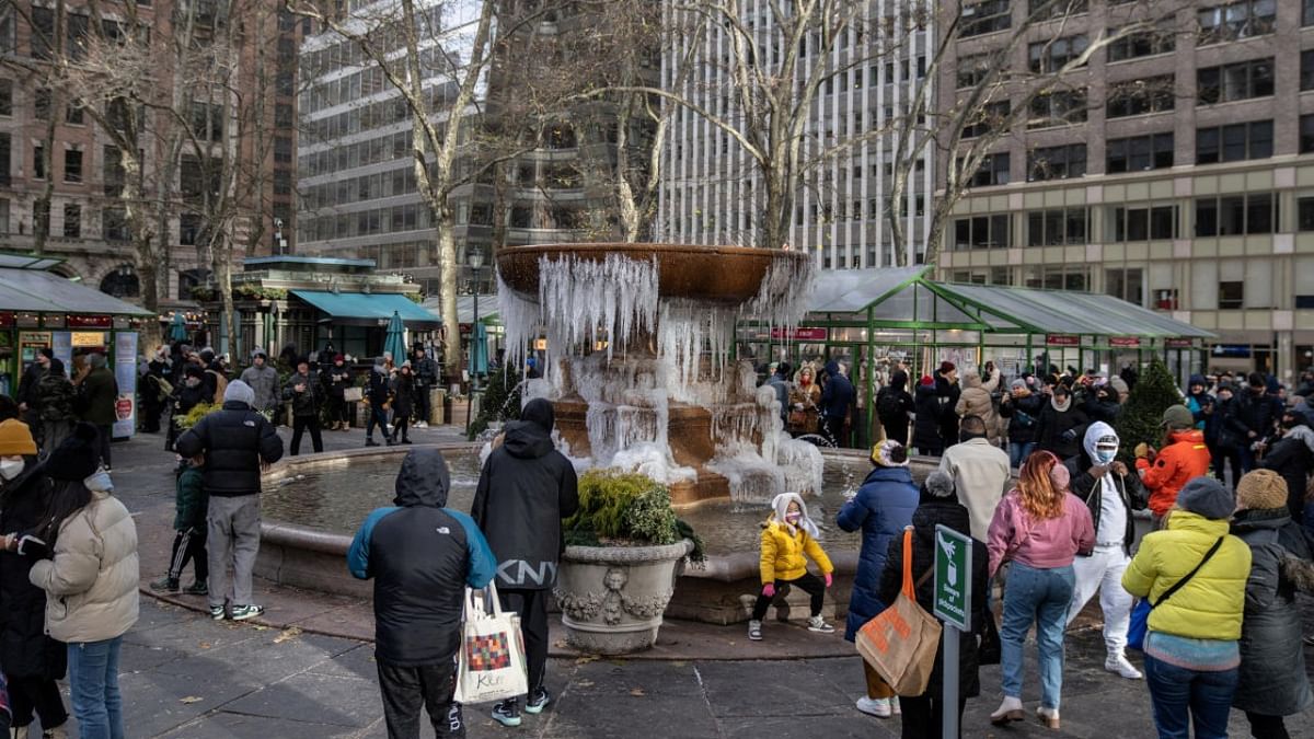 People walk around of a mostly frozen Bryant Park fountain on Christmas Eve in Manhattan, New York City. Credit: Reuters photo