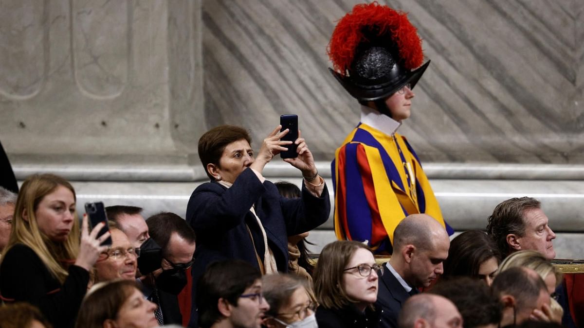 People take pictures with their cellphones as Pope Francis celebrates Christmas Eve mass in St. Peter's Basilica at the Vatican. Credit: Reuters photo
