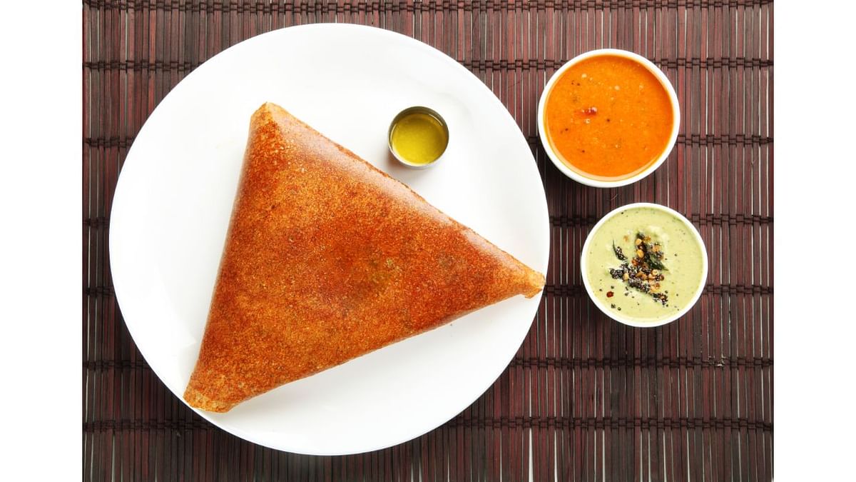 Masala Dosa: A staple for South Indians, masala dosa is served with mint and coconut chutney and piping hot sambhar, along with potato pudding. One can make it more crispy by adding ghee and butter. Credit: Getty Images