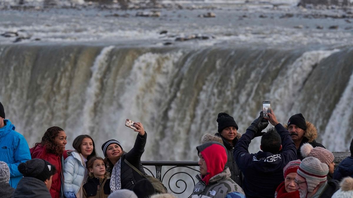 Tourists take photographs at the Horseshoe Falls. Credit: AFP Photo