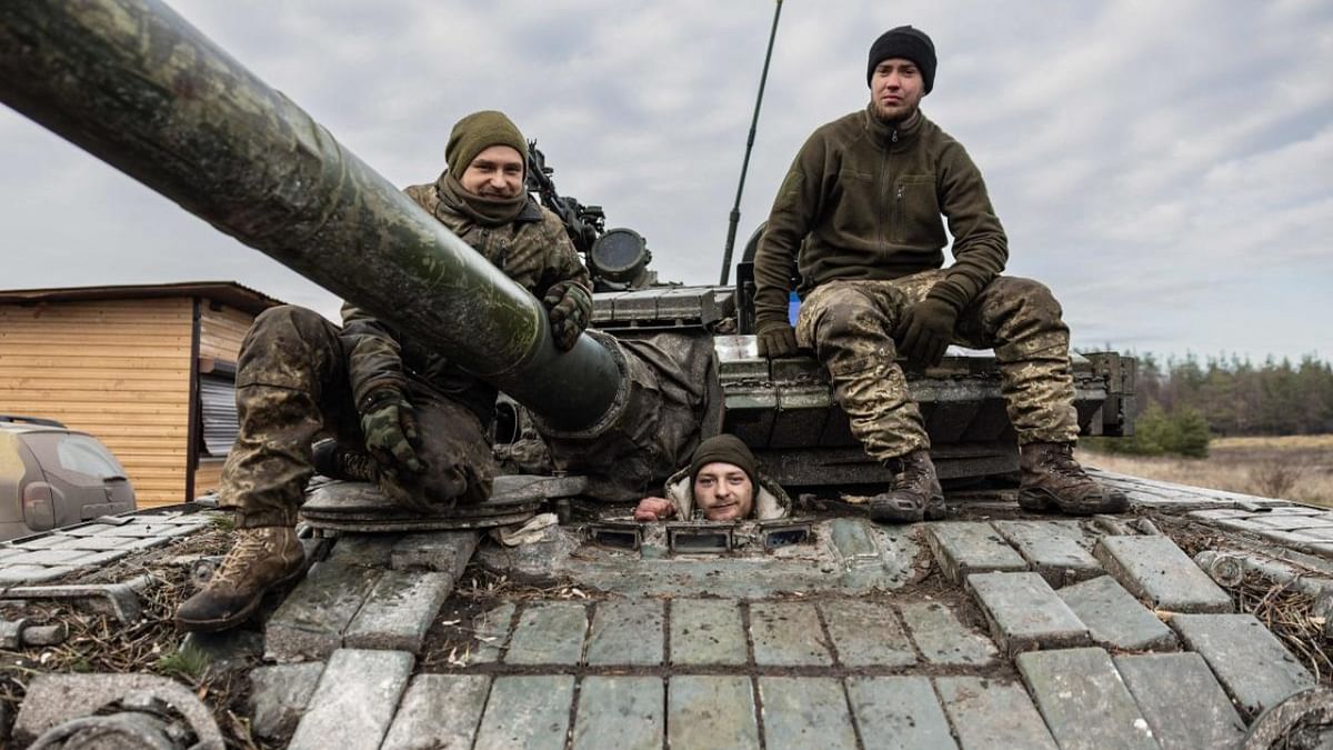 Ukrainian servicemen pose on a T-80 tank in an undisclosed location in eastern Ukraine on December 29, 2022, amid Russian invasion of Ukraine. Credit: AFP Photo