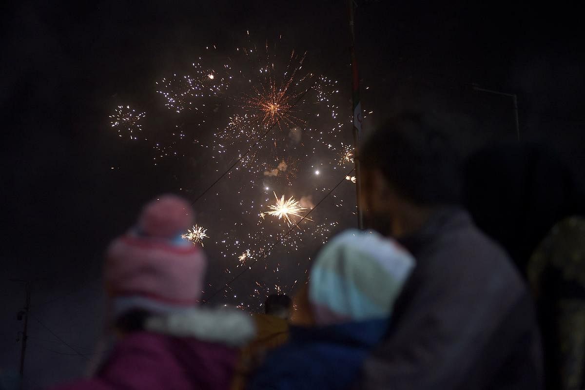 Revellers watch a fireworks show during New Year celebrations in Karachi. Credit: AFP Photo