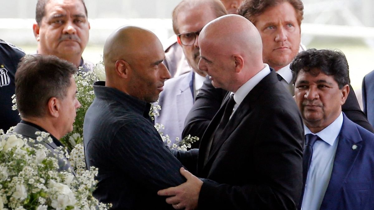 Pele's son Edinho shakes hands with FIFA president Gianni Infantino during the funeral. Credit: Reuters Photo