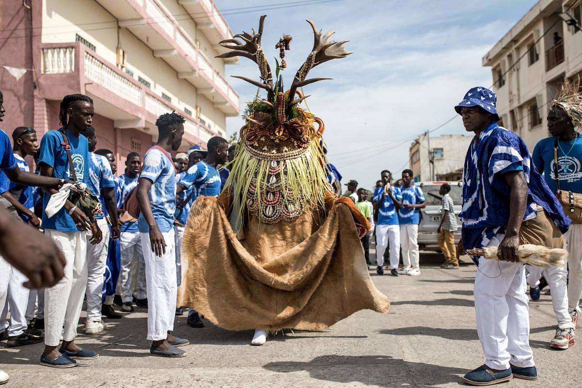 A hunting society reveals its costume at the annual hunting festival in Banjul. This hunting festival occurs every new years in Banjul. The two groups 'Ekum Baba' and 'Odilleh' come to the streets of Banjul every year to battle for the title of best animal heads,masques and costumes. Credit: AFP Photo