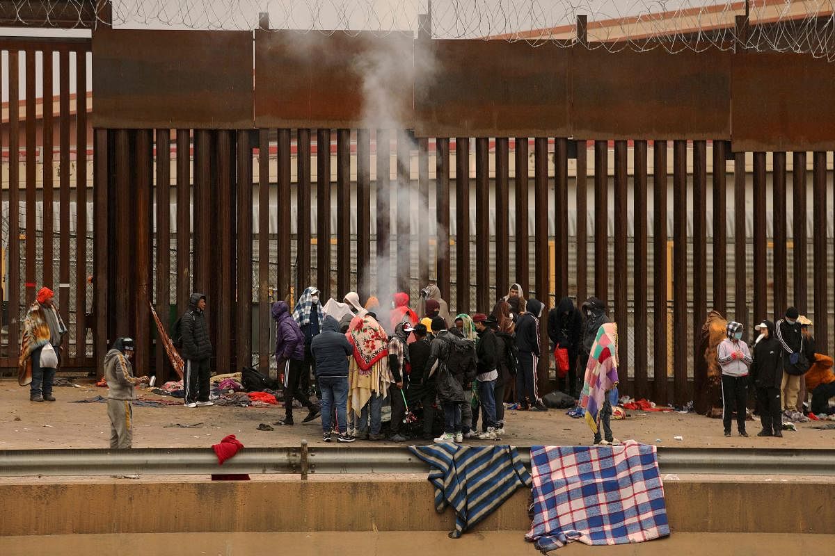 Migrants seeking asylum in the United States stand around a fire to keep warm after crossing the Rio Grande from Ciudad Juarez in Chihuahua, Mexico. Credit: AFP Photo