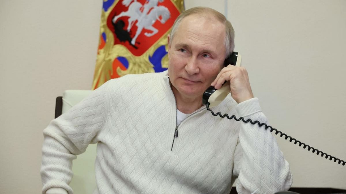 Russian President Vladimir Putin talks on the phone with David Shmelev, a seven-year-old child from Stavropol Krai region, who took part in the New Year Tree of Wishes nationwide charity campaign, at the Novo-Ogaryovo state residence, outside Moscow on January 5, 2023. Credit: AFP Photo