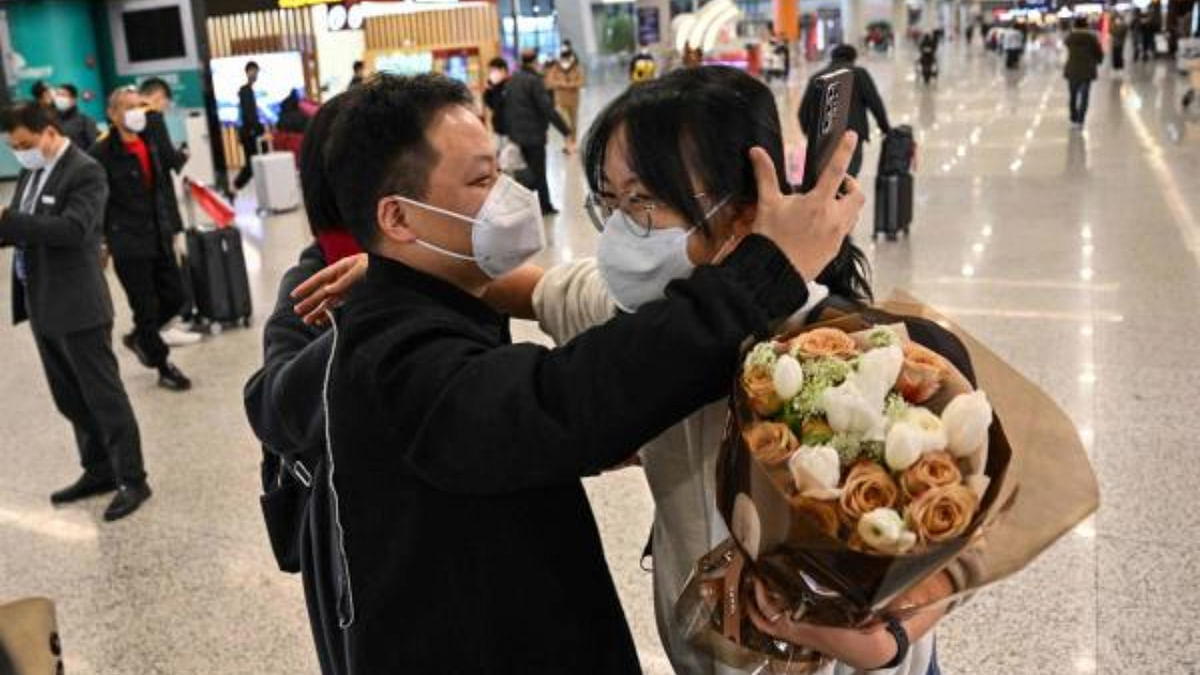 A passenger (R) receives a hug while leaving the arrival area of international flights at the Shanghai Pudong International Airport, in Shanghai. Credit: AFP Photo