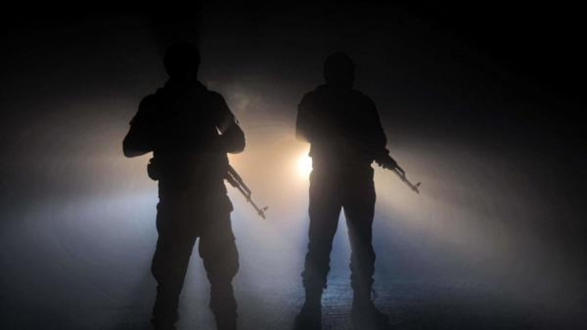 Syrian rebel fighters stand before the headlights of a vehicle in heavy fog. Credit: AFP Photo