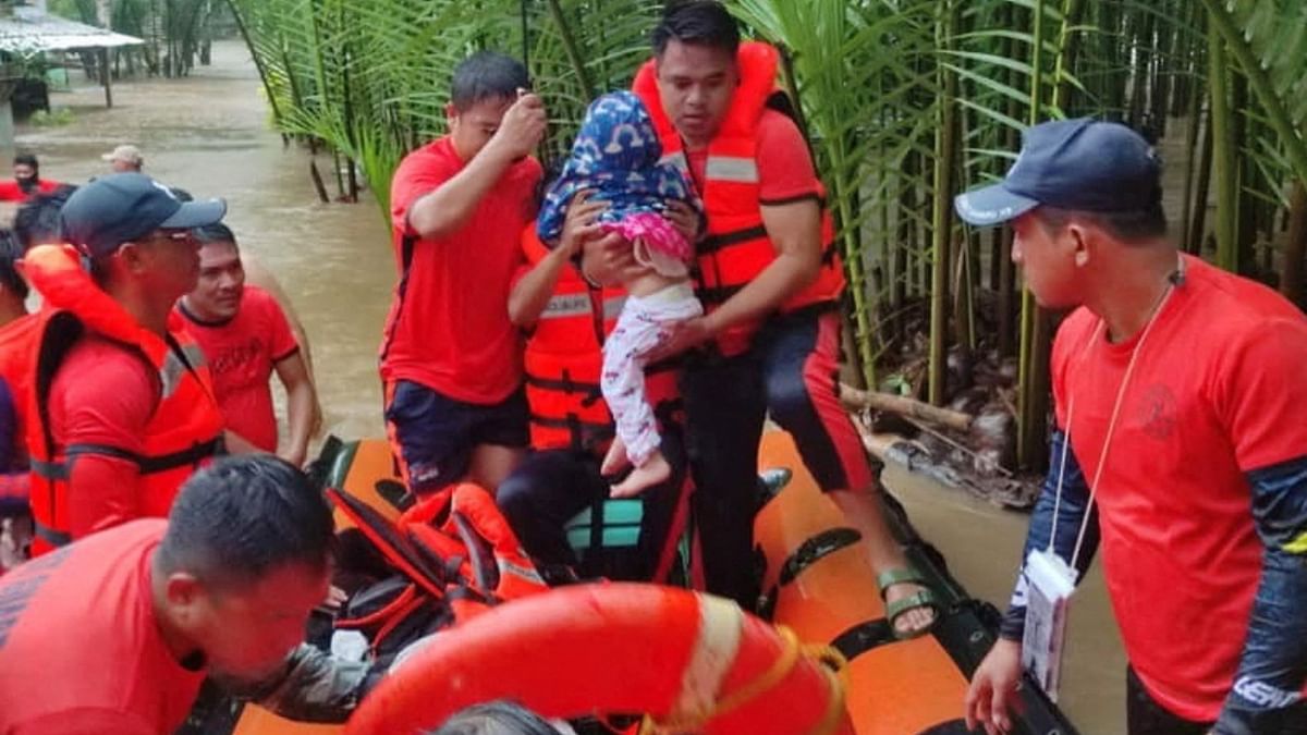 Members of the Philippine Coast Guard carried those affected by floods during their rescue operation, in Lamitan City, Basilan province, Philippines. Credit: Reuters Photo