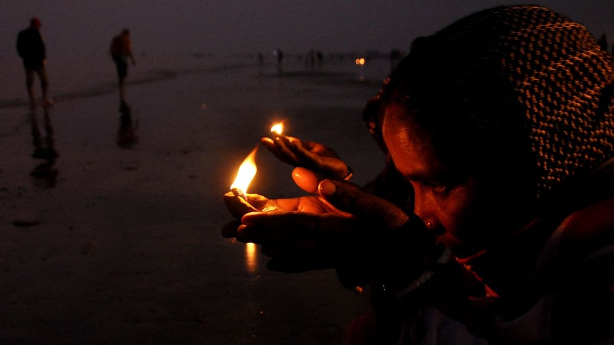 People perform rituals after taking a dip at Ganga during the Gangasagar Mela on the occasion of Makar Sankranti. Credit: AFP Photo