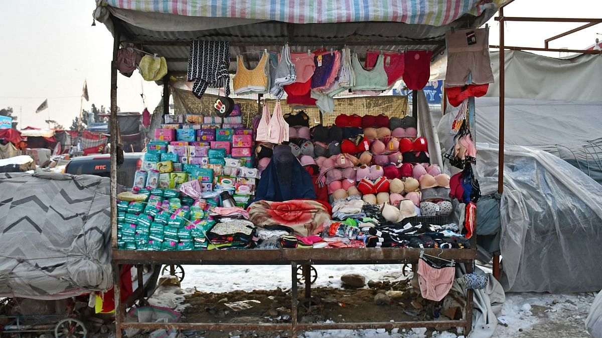 An Afghan burqa-clad woman vendor selling products for women and children, waits for customers at her roadside stall in Mazar-i-Sharif. Credit: AFP Photo