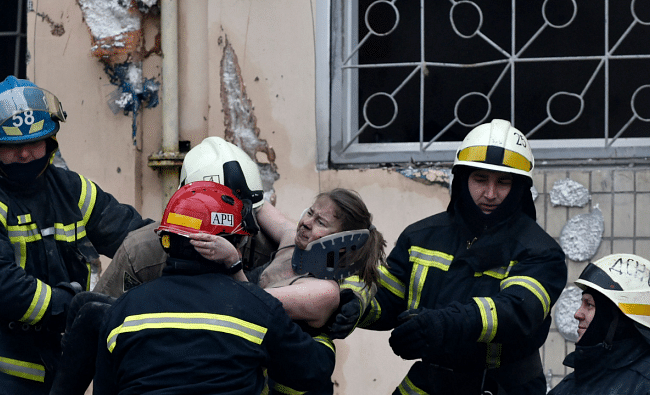 Rescuers carry a woman evacuated from the rubble of a residential building destroyed after a missile strike, in Dnipro. Credit: AFP Photo