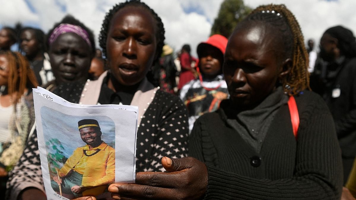 Friends and relatives look through the funeral program of Kenyan LGBTQ activist Edwin Chiloba, who was smothered to death in a killing that caused outrage, during his funeral in Sergoit village, in Eldoret. Credit: AFP Photo