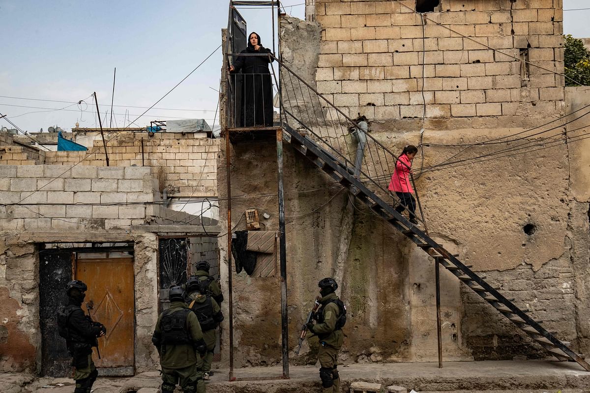 Syrian Kurdish Asayish security forces search houses during a raid against suspected Islamic State group fighters in Raqa, the jihadist group's former defacto capital in Syria, on January 28, 2023. Credit: AFP Photo