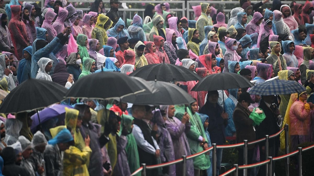 People wearing raincoats sit to watch the Beating Retreat ceremony, at Vijay Chowk in New Delhi. Credit: PTI Photo
