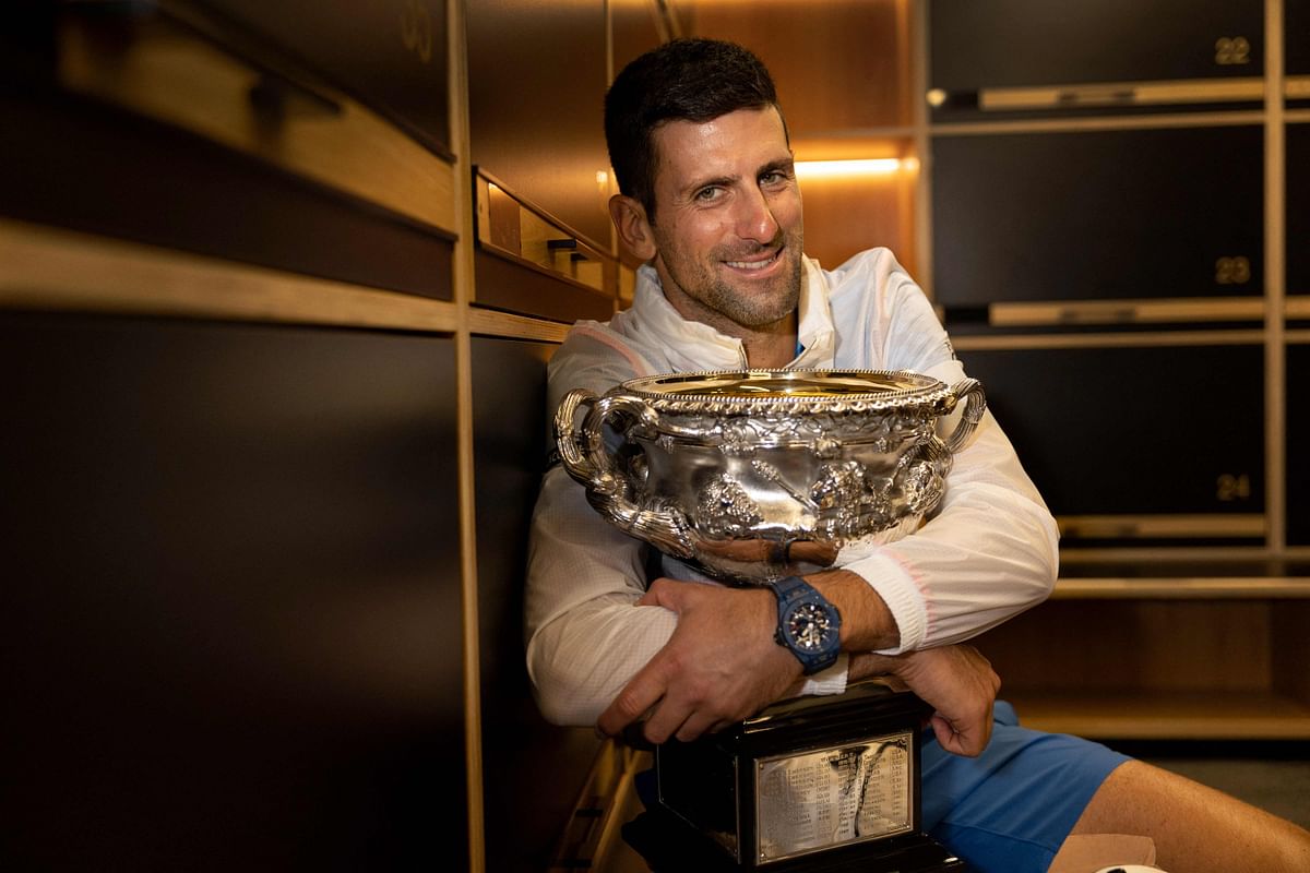 This handout picture released by Tennis Australia on January 30, 2023, shows Serbia's Novak Djokovic poses with the 2023 Australian Open men's singles final trophy at the locker room in Melbourne. Credit: AFP Photo