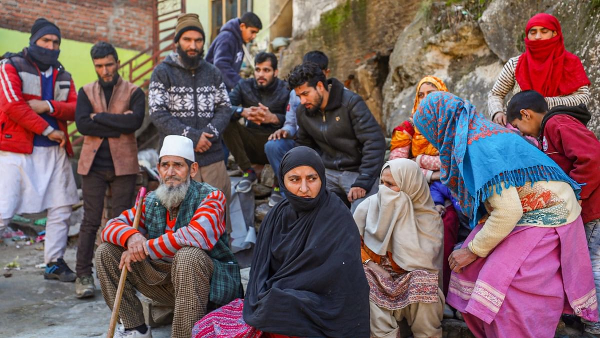 Residents sit on a road after cracks appeared in their houses in Nai Basti area, Doda district, Jammu and Kashmir. Credit: PTI Photo