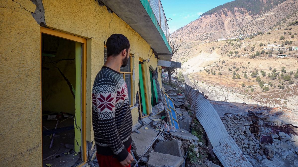 A resident shows cracks that have appeared in his house in Nai Basti area in Doda district, Jammu and Kashmir. Credit: PTI Photo