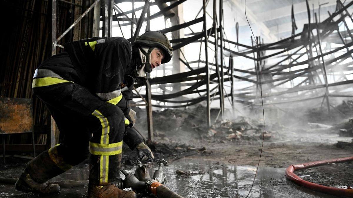 A Ukrainian firefighter works to put out fire in a shopping mall following a Russian shelling in Kherson. Credit: AFP Photo