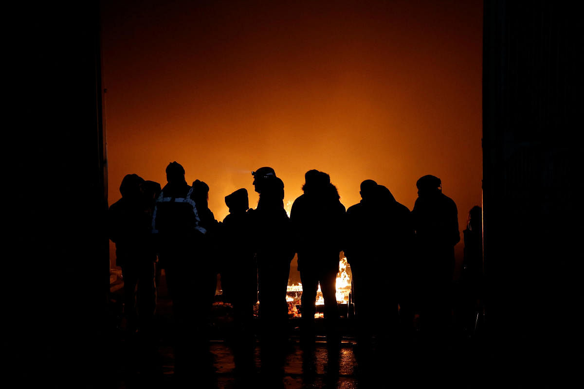 Rescuers and local people gather around a bonfire near a collapsed building, following an earthquake in Osmaniye, Turkey. Credit: Reuters Photo