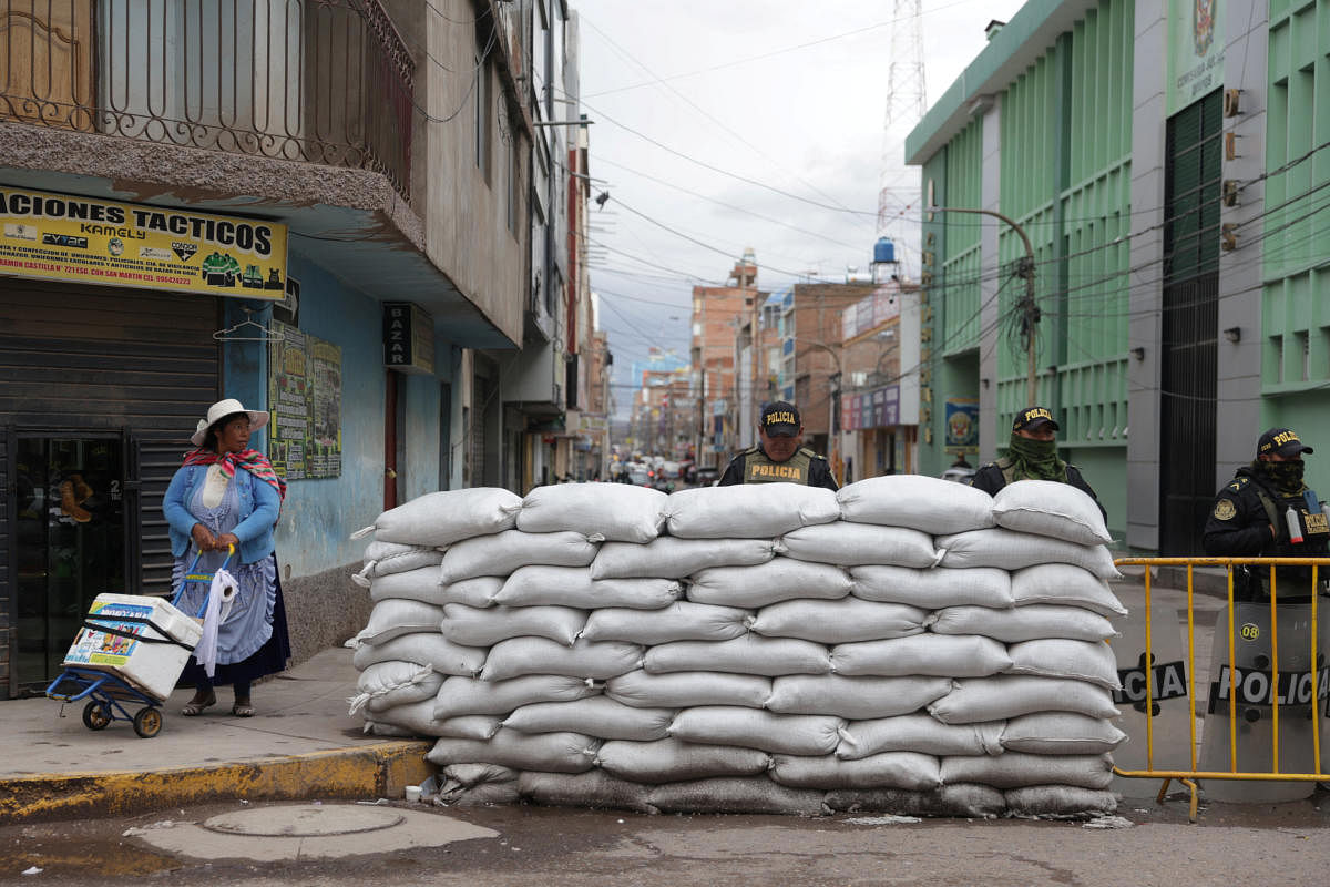 A woman walks next to a police barricade on a street, as protests and roadblocks in Peru's southern Andes have hardened after Congress failed to bring forward elections, in Juliaca, Peru February 7, 2023. Credit: REUTERS/Pilar Olivares