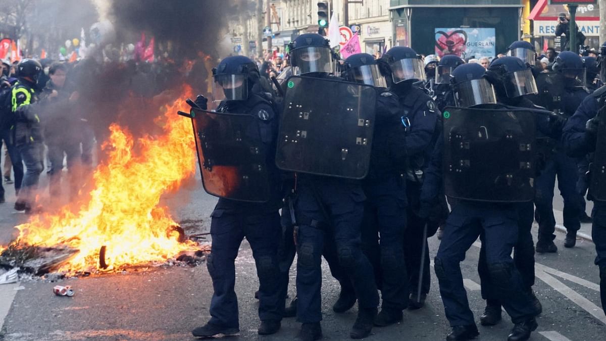 Law enforcement officers walk next to a fire during a demonstration against the French government's pension reform plan as part of the fourth day of national protests, in Paris, France, February 11, 2023. Credit: Reuters Photo