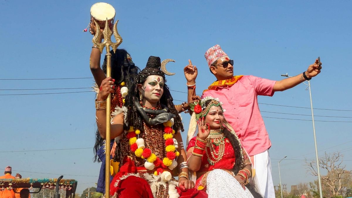 Artists dressed as Lord Shiva and Goddess Parvati during a procession on the occasion of 'Maha Shivratri', in Bhopal. Credit: PTI Photo