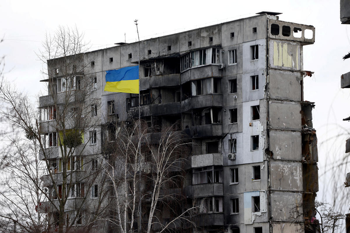 Ukrainian national flag flies in front of a destroyed residential building amid Russia's invasion of Ukraine, in Borodianka, Kyiv region, Ukraine. Credit: Reuters Photo