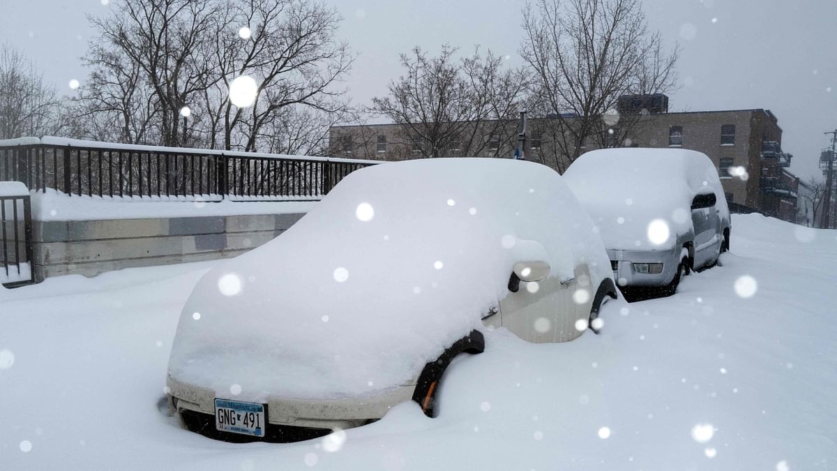 Snow falls as cars sit parked under a blanket of snow in Minneapolis, Minnesota. Credit: Getty Images