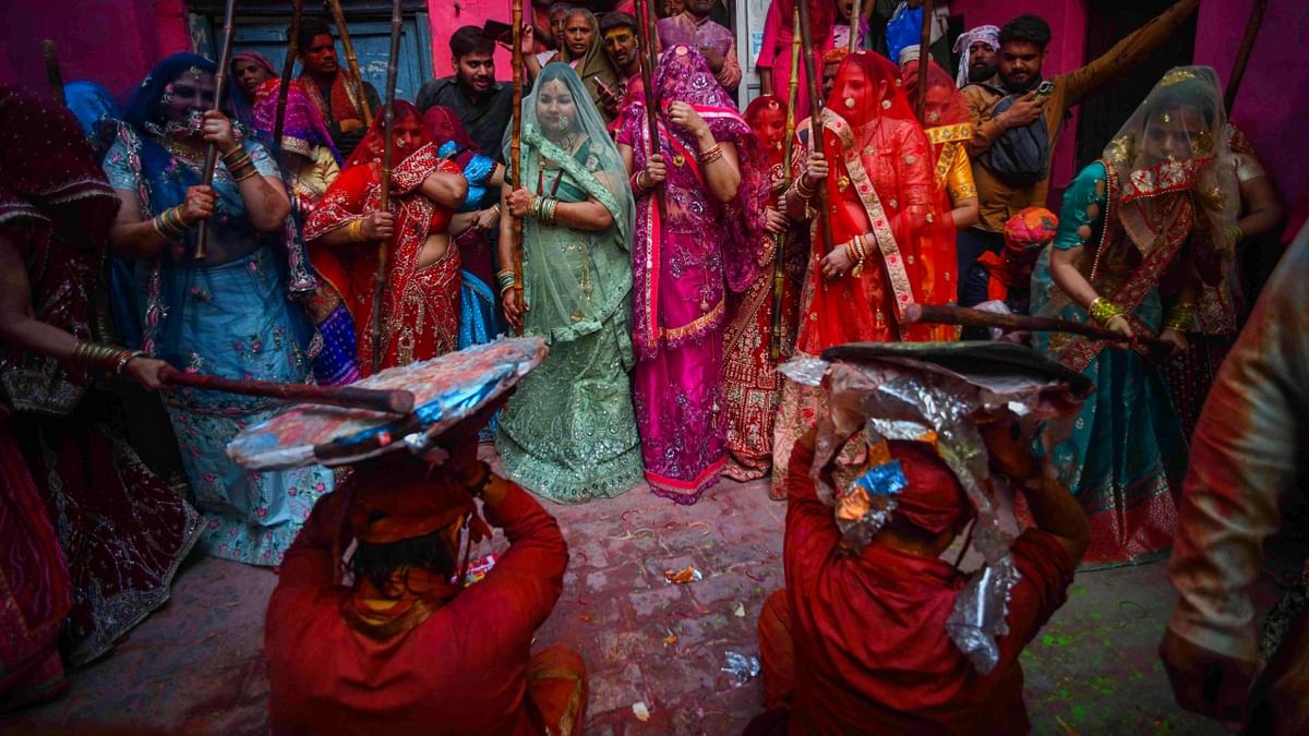 Every year, thousands of devotees and tourists are attracted to the town here to witness ‘Lathmar Holi’, the festival that honours the couple, Radha and Krishna. Credit: PTI Photo