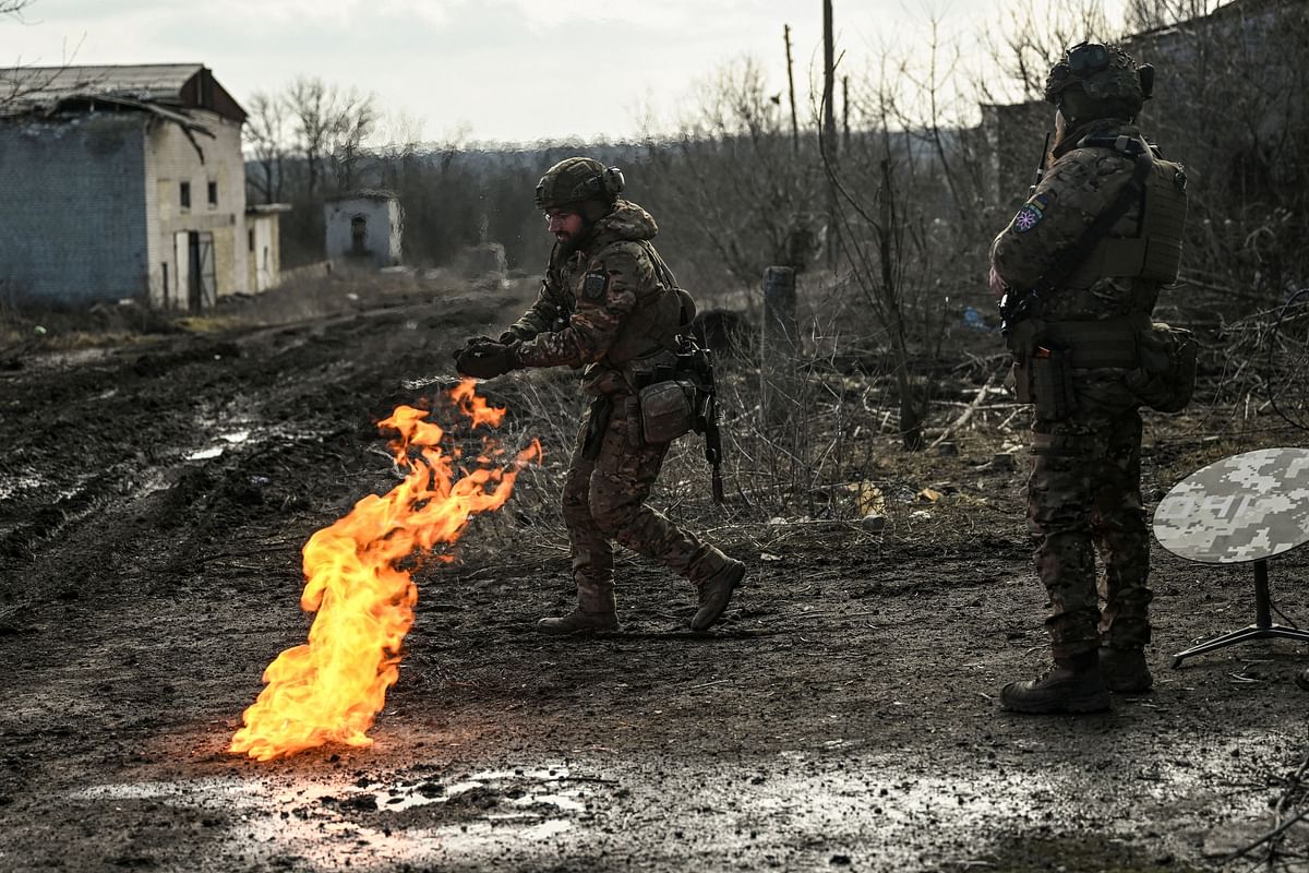 Ukrainian servicemen light a fire with gun powder to get warm near the city of Bakhmut in the region of Donbas. Credit: AFP Photo