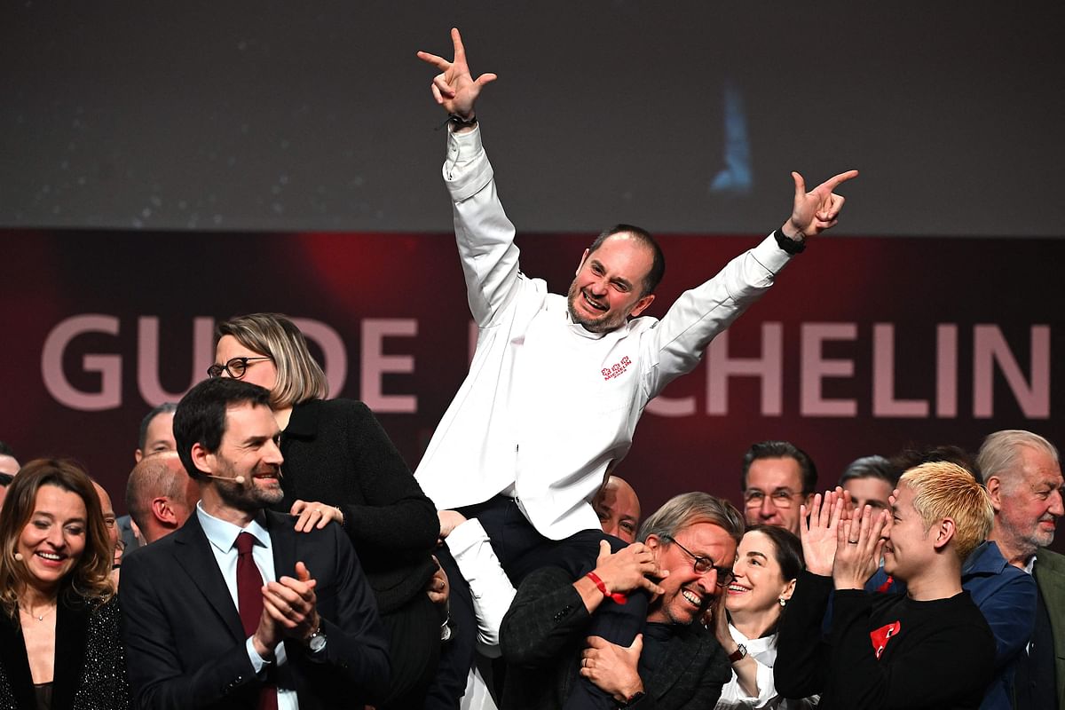 Alexandre Couillon celebrates after being awarded a third Michelin star, during the 2023 edition of the Michelin guide awards ceremony. Credit: AFP Photo