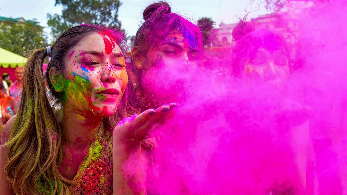 Foreign tourists play with colours during celebrations of Holi festival at Khasa Kothi in Jaipur. Credit: PTI Photo