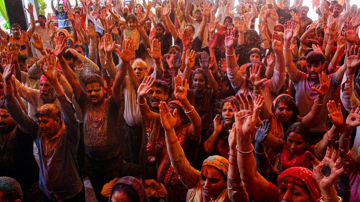 People smeared in colours chant slogans as they celebrate Holi, in Gurugram. Credit: PTI Photo