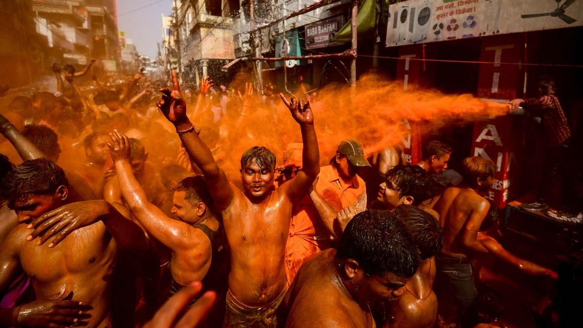 Daubed in colours, people groove to foot tapping numbers during Holi celebrations, in Prayagraj. Credit: AFP Photo