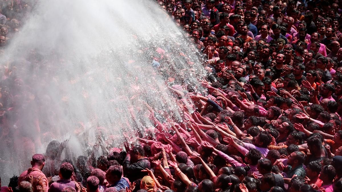 Devotees gets showered with coloured water at a temple's premises, during Holi celebrations in Ahmedabad. Credit: Reuters Photo