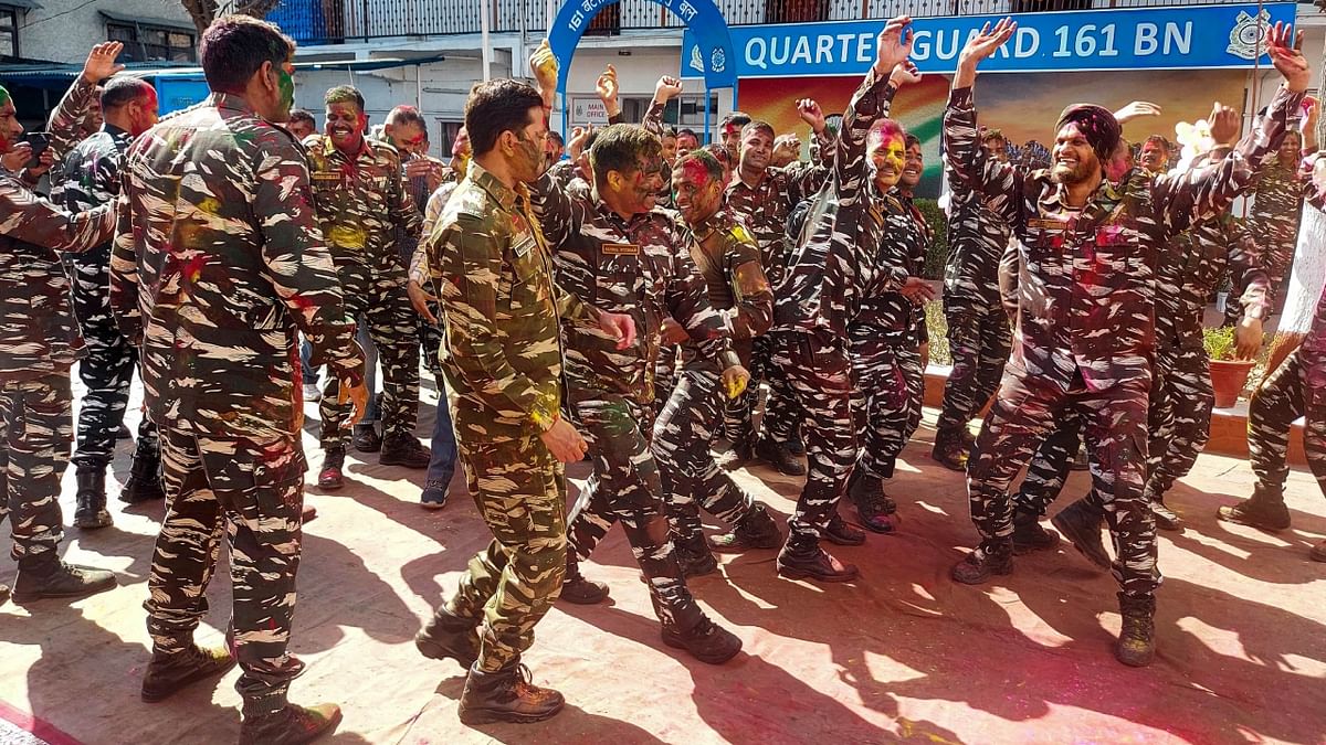 CRPF personnel dance as they celebrate Holi festival, at a camp in Srinagar. Credit: PTI Photo