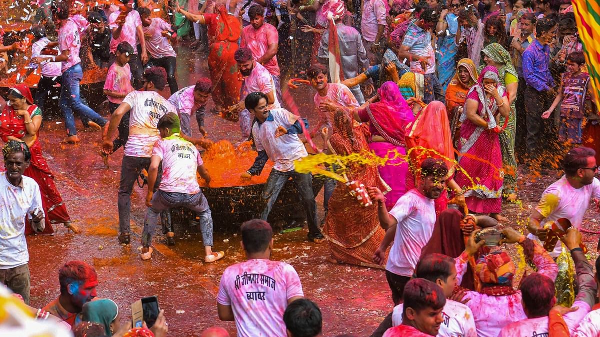 People throw water colour on each other as they celebrate 'Kodamar Holi', in Beawar, Rajasthan. Credit: PTI Photo