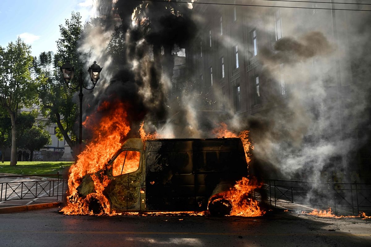 A van burns in the centre of Athens during a nationwide day of mass strikes and protests over the country's worst rail tragedy. Credit: AFP Photo