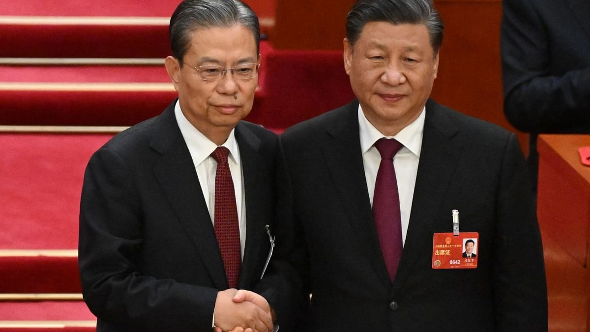Newly-elected National People's Congress Chairman Zhao Leji (L) shakes hands with China's President Xi Jinping during the third plenary session of the National People's Congress (NPC) in Beijing. Credit: AFP Photo