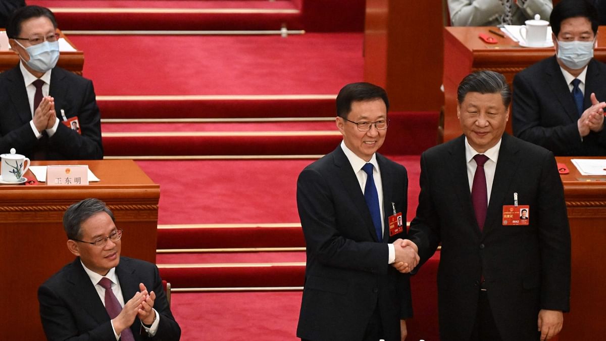 Newly-elected Vice President Han Zheng (C) shakes hands with China's President Xi Jinping (R) during the third plenary session of the National People's Congress (NPC) in Beijing. Credit: AFP Photo
